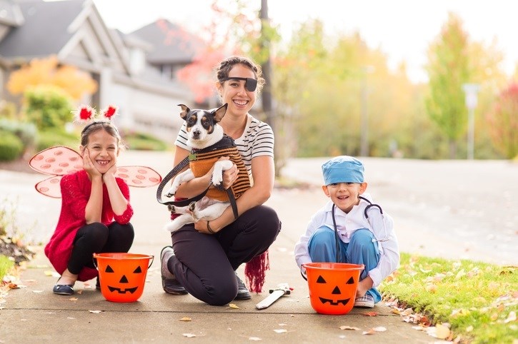 Family and dog trick or treating together.