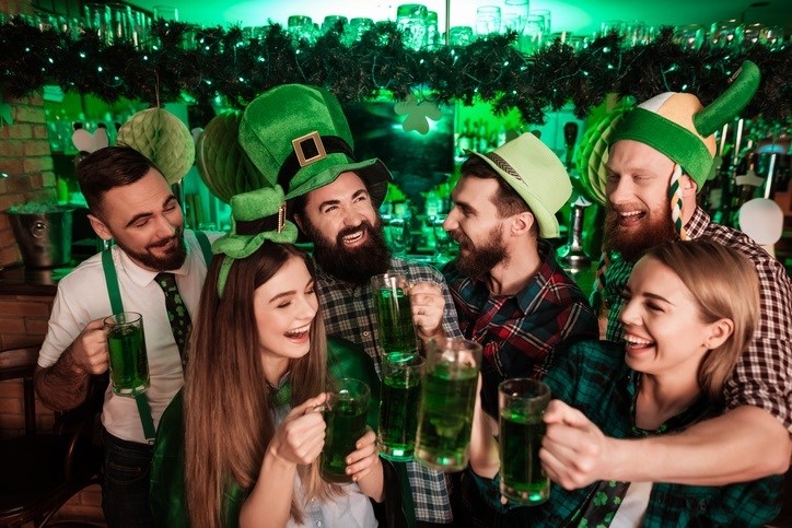 Friends celebrating St. Patrick's day together. Silly green hats, green beer and smiling faces all around!