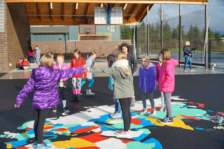 Kids playing outside on colorful school ground during recess.