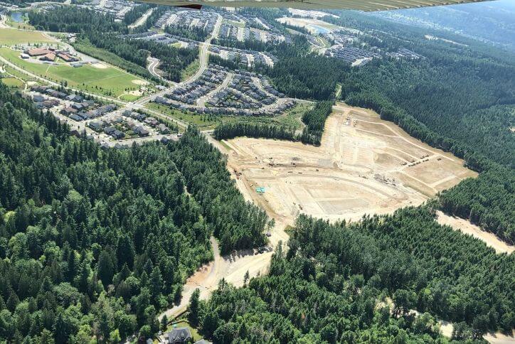 Bird's eye view of pine tree forest and open spaces around Tehaleh.