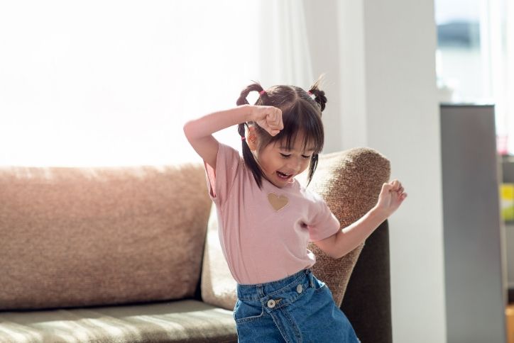 Little asian girl dancing at home.