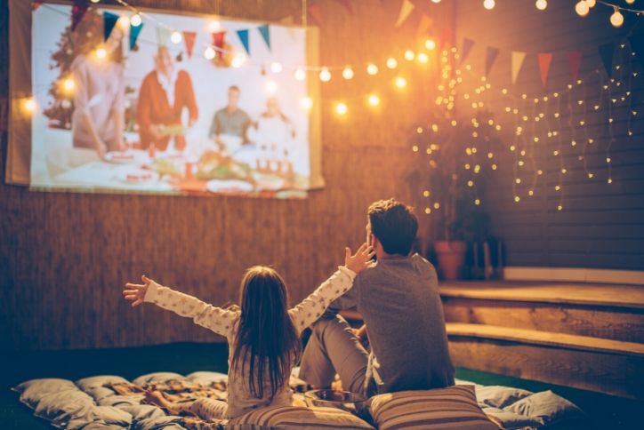 Father and daughter watching a movie in their self-made home theater.