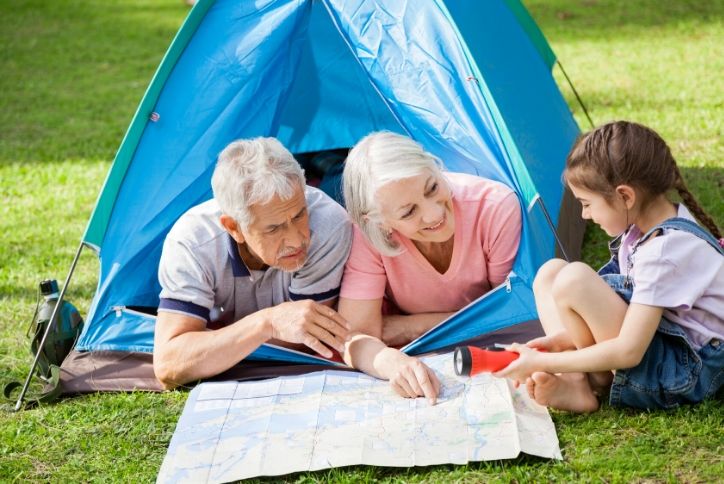 Grandparents camping in the backyard with their granddaughter.