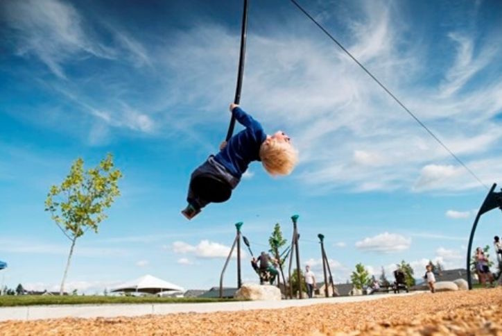 Young kid on swing with head happily tilted back.