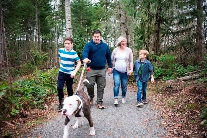 Family walking their dog through Tehaleh woods.