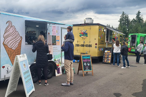 Residents order food at food trucks in Discovery Park
