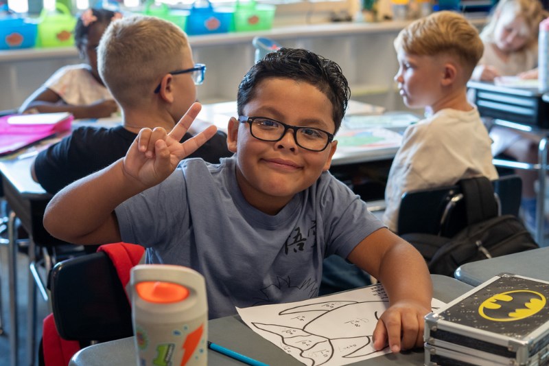 Young Orting student poses for a picture in his classroom