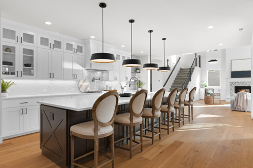 A beautiful JK Monarch Homes kitchen featuring a long island and high end light fixtures.