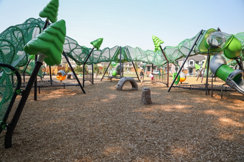 Children playing around a serpent shaped playground.