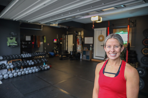 Tehaleh Ambassador, Jaclyn Hahn, stands proud next to her Evolve Fitness studio in her home garage.